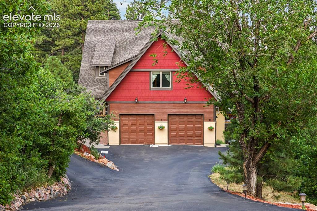 Image 3 of 50: A tree-lined driveway creates a memorable arrival with the home tucked priv