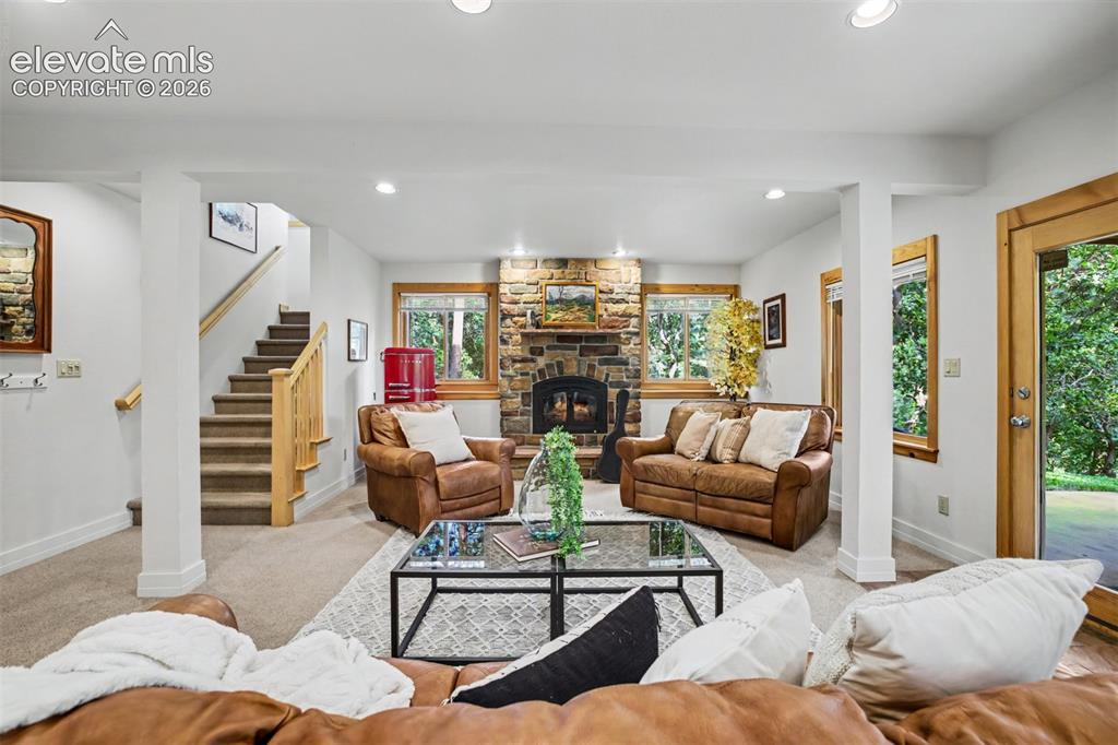 Image 34 of 50: The basement walk-out family room features a wood-burning fireplace, wet ba
