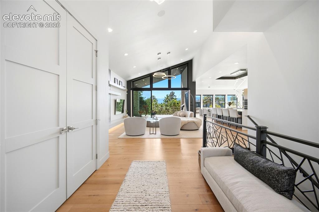 Image 12 of 50: Vaulted ceilings with recessed lighting, light wood-finish flooring, and a