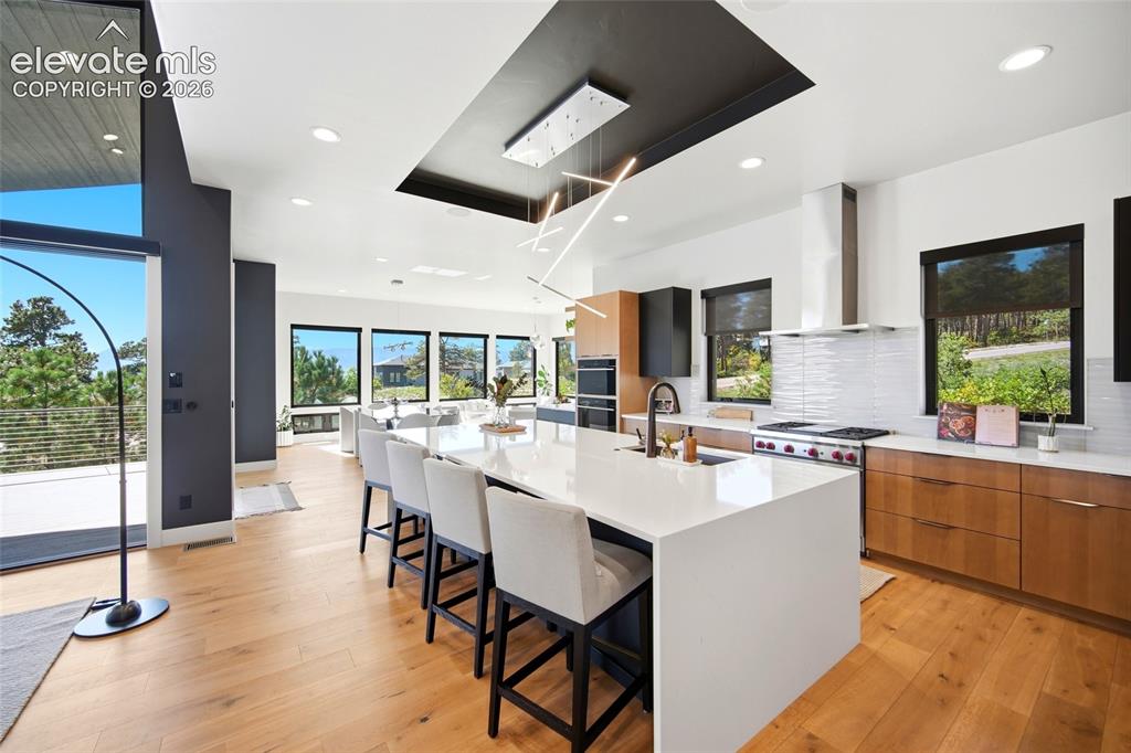 Image 19 of 50: Open-concept kitchen featuring a large central island with seating, stainle