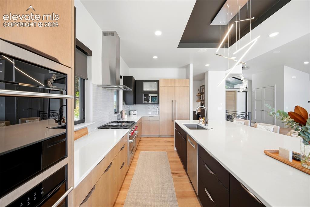 Image 20 of 50: Gourmet kitchen featuring a stainless steel wall oven, gas range with hood,