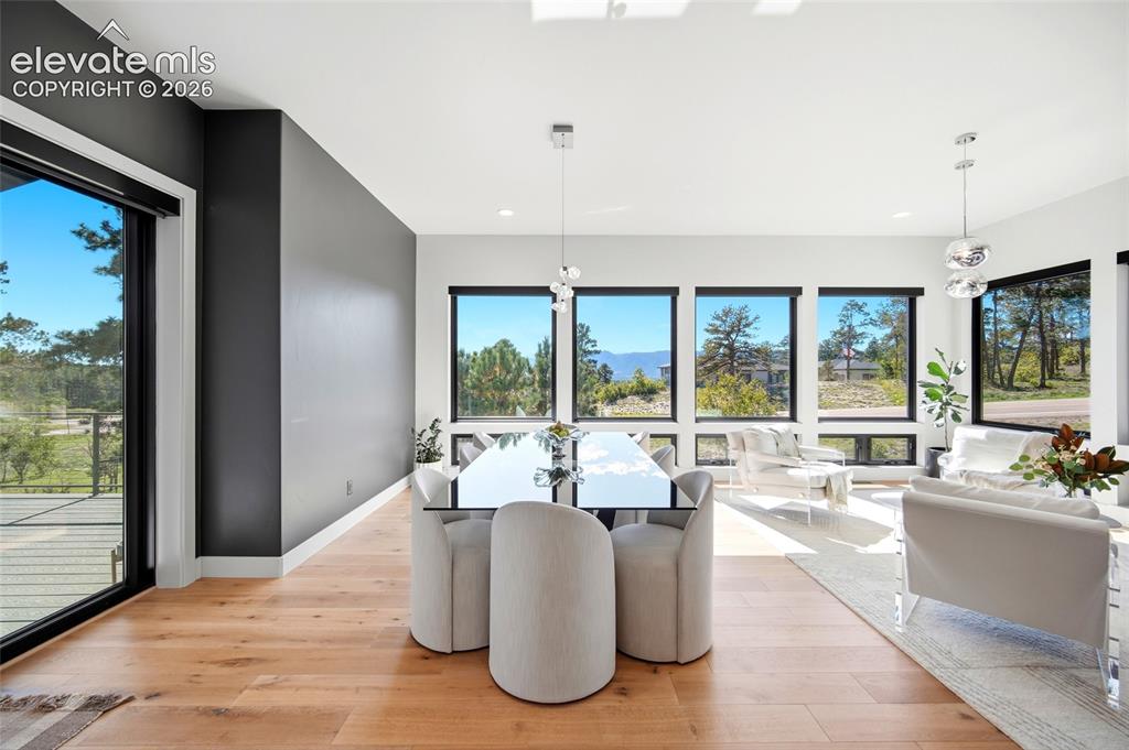 Image 22 of 50: Open-concept living space featuring wood-finish flooring, a full wall of ex