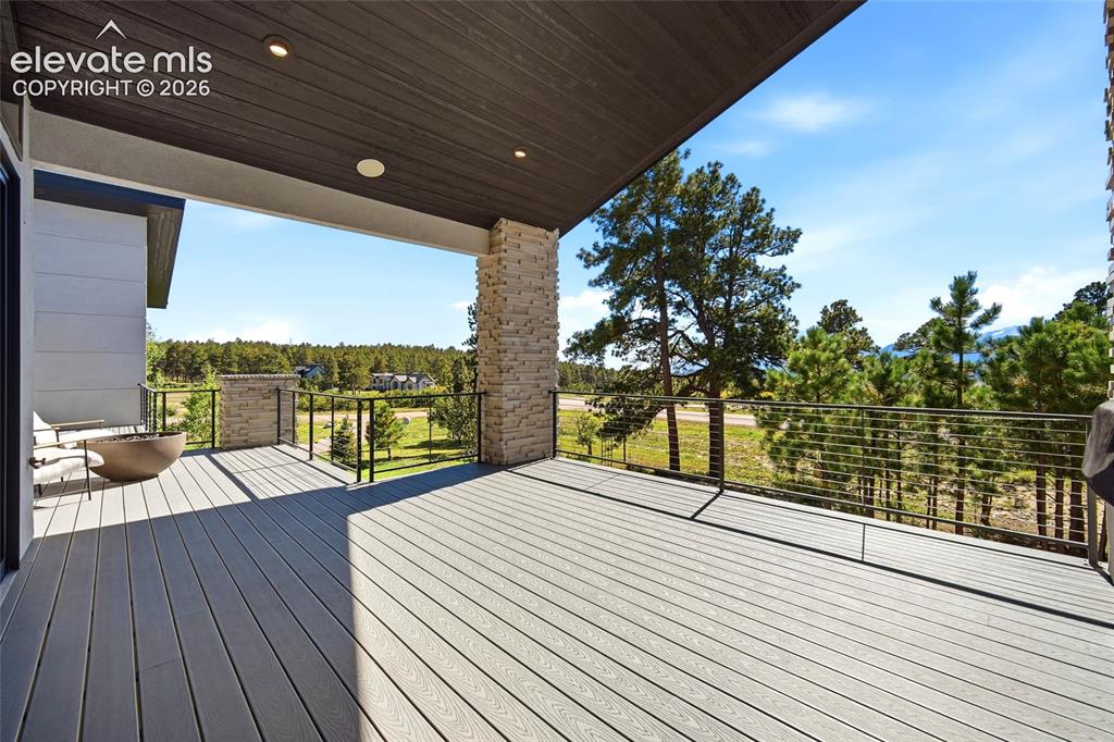 Image 25 of 50: Spacious covered deck featuring composite decking, recessed lighting, and c