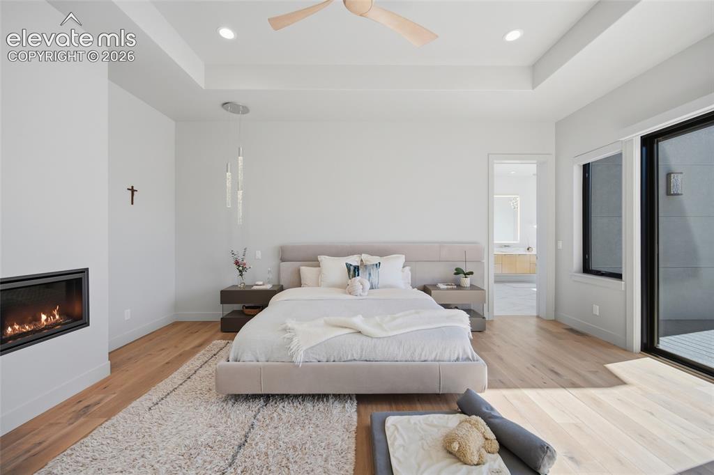 Image 29 of 50: Recessed lighting, wood-finish flooring, ceiling fan, contemporary fireplac