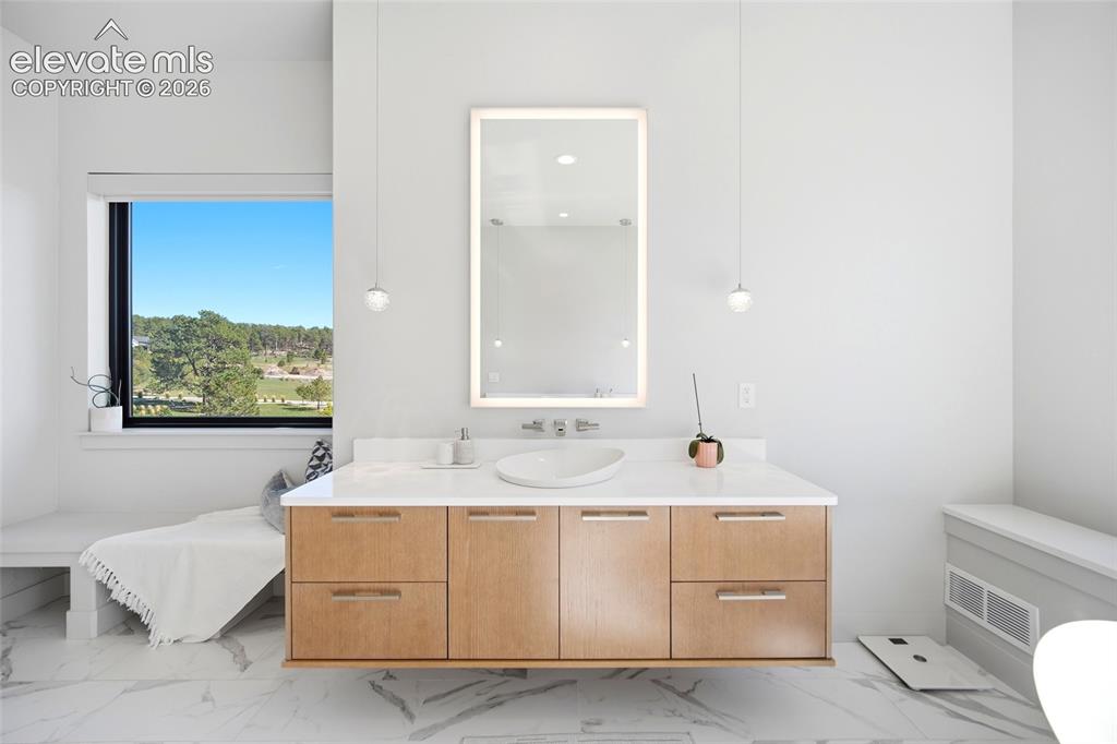 Image 31 of 50: Floating wood-finish vanity with an integrated vessel sink, white counterto