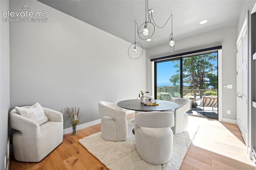 Image 34 of 50: Sliding glass door to an exterior patio, wood-finish flooring, recessed lig