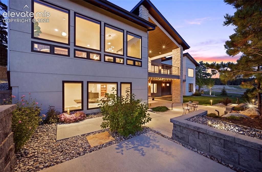 Image 36 of 50: Modern exterior with expansive windows, a second-story balcony with metal r