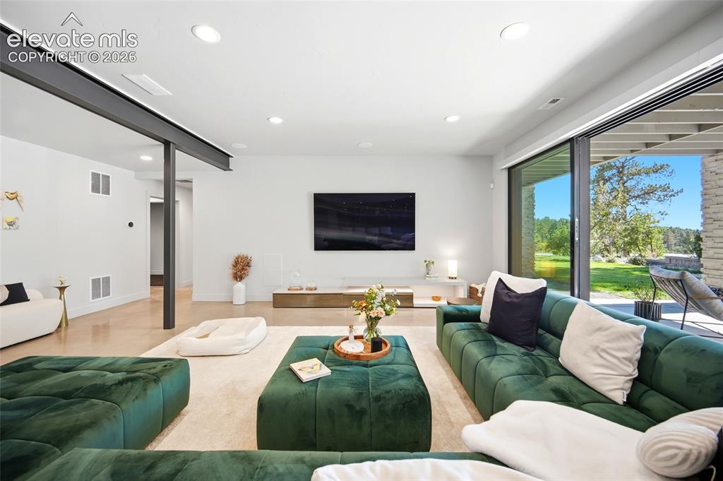 Image 38 of 50: Spacious living area featuring recessed lighting, a structural beam, wood-f