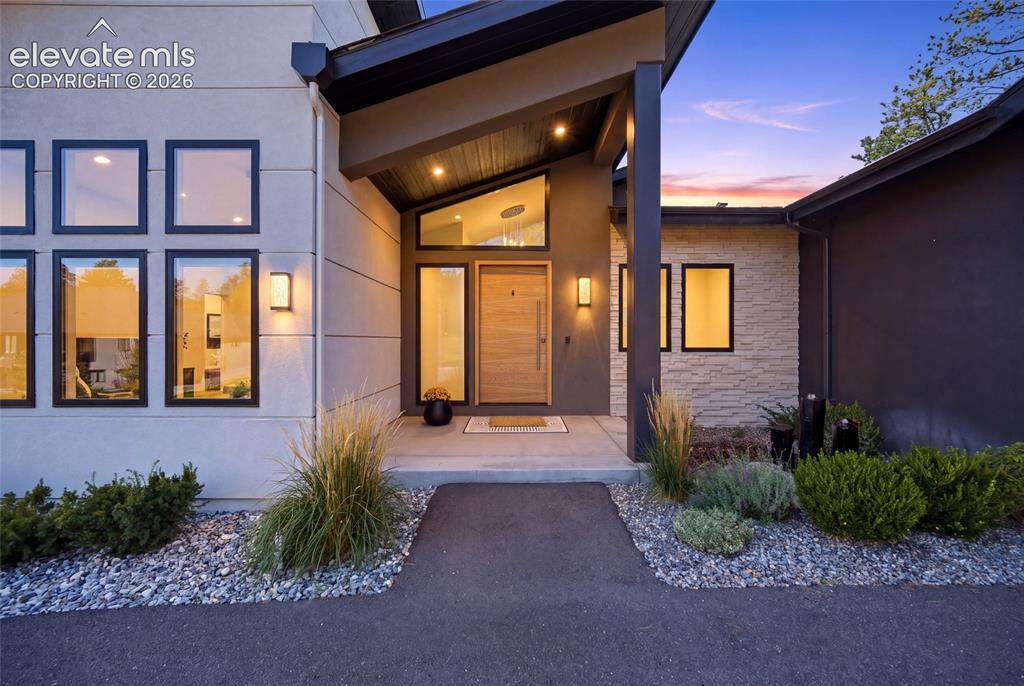 Image 4 of 50: Modern exterior with a light-colored stucco finish, stacked stone accents, 