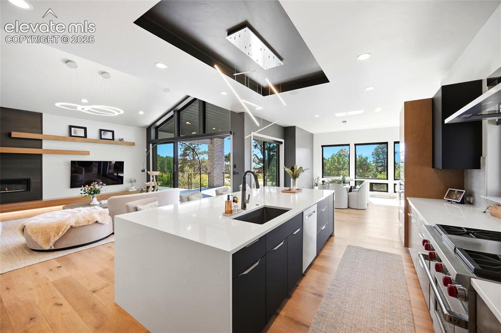 Image 5 of 50: Open-concept living space featuring wood-finish flooring and a vaulted ceil