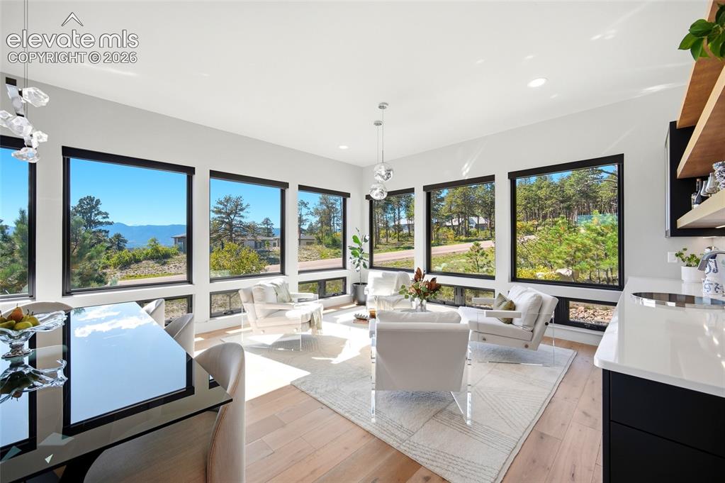 Image 7 of 50: Spacious living area featuring expansive windows, recessed lighting, wood-f