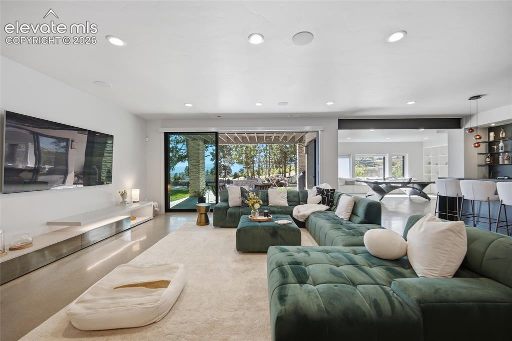 Image 9 of 50: Recessed lighting, large format tile flooring, built-in media console, slid