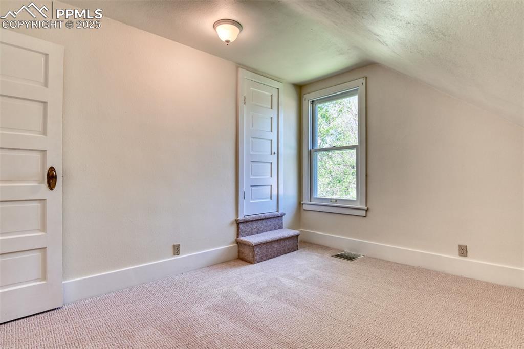 Image 46 of 50: 4th bedroom has the quaint farm charm with the sloping ceiling