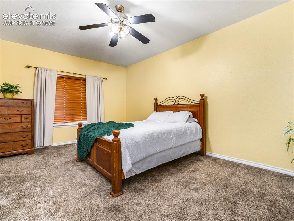 Image 12 of 49: Ceiling fan with integrated lighting, wood-finish window blinds, and instal