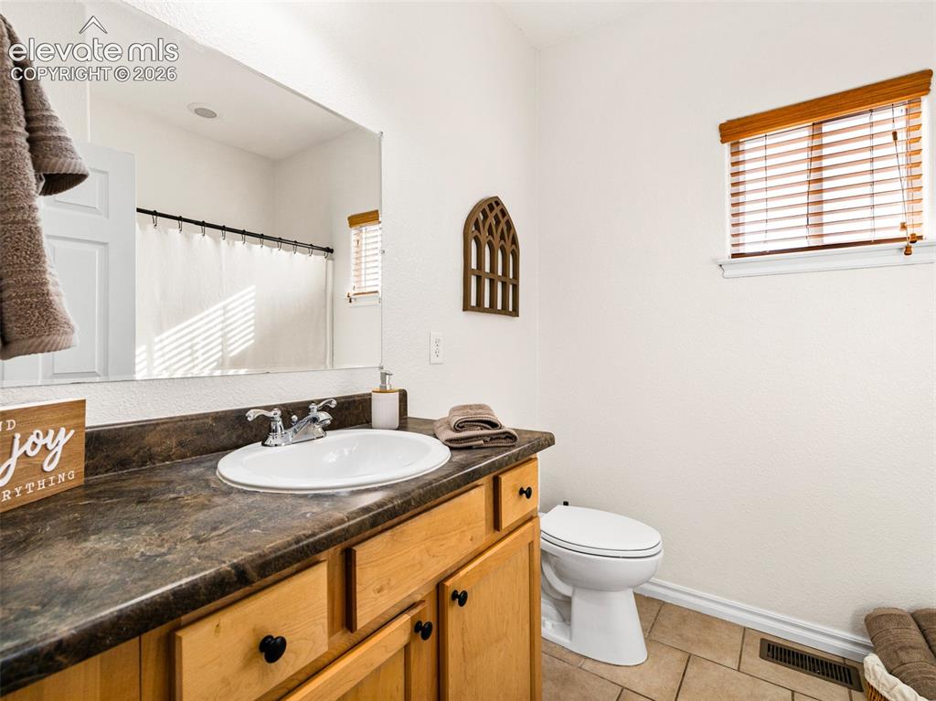 Image 17 of 49: White vanity with a laminate countertop, undermount sink, and chrome faucet