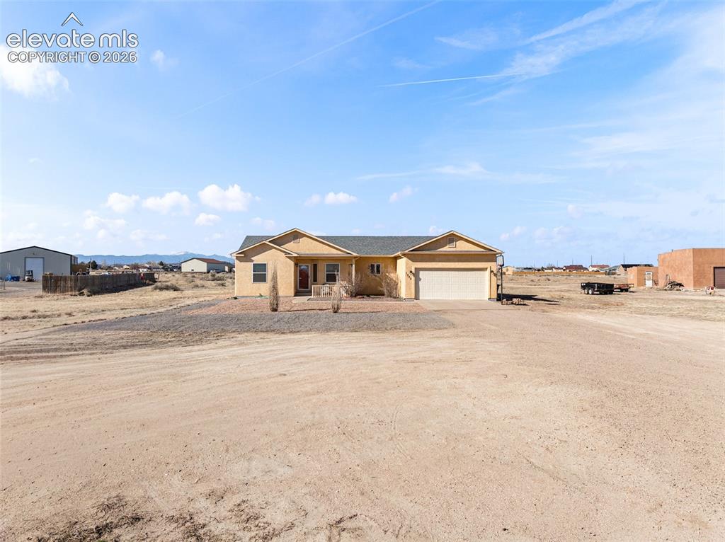 Image 24 of 49: Single-story stucco exterior with an attached two-car garage