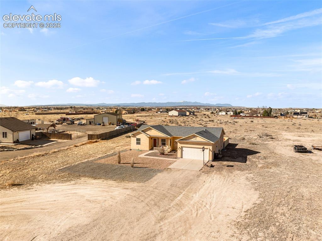 Image 25 of 49: Single-story residence featuring a two-car garage, pitched roof, and an ope
