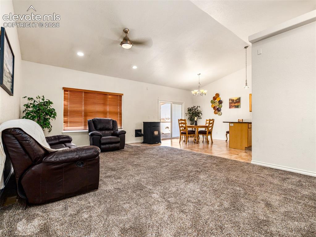 Image 3 of 49: Vaulted ceilings with recessed lighting, carpet flooring, wood-finish floor