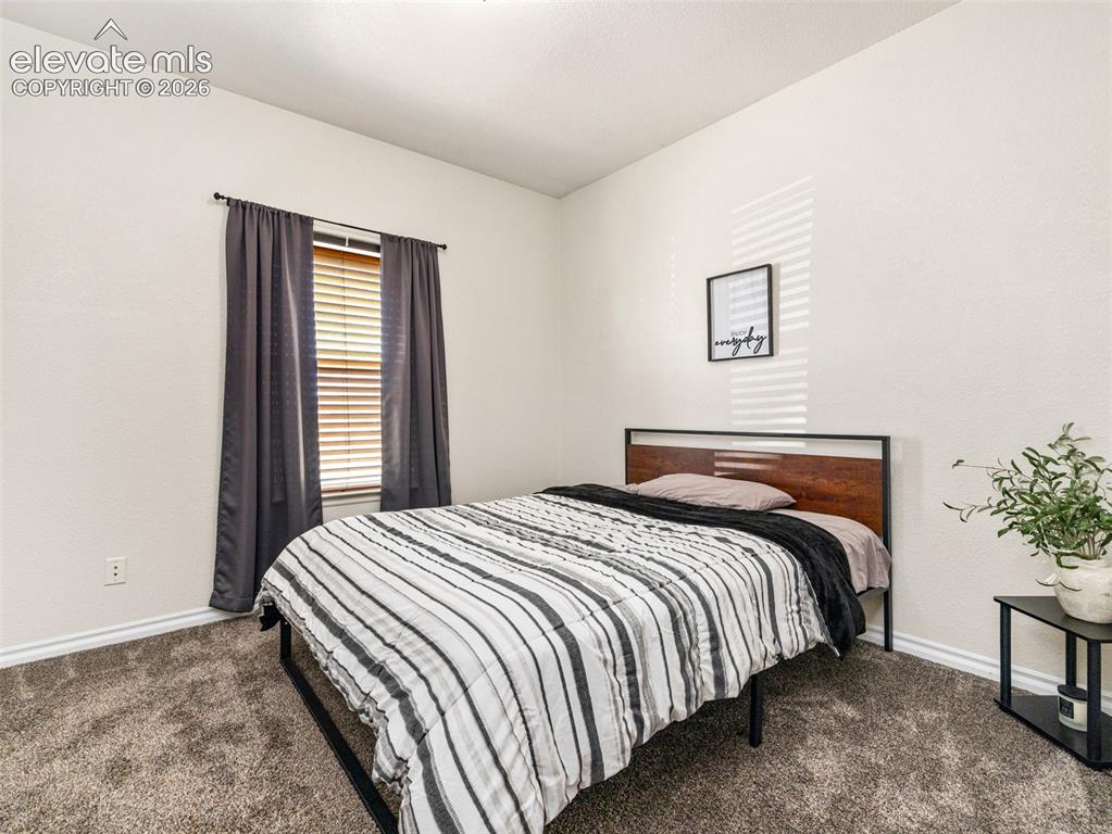 Image 39 of 49: Carpeted flooring, a window with horizontal blinds, and neutral wall tones