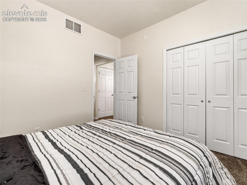 Image 40 of 49: Neutral wall color, textured ceiling, white trim, white paneled doors, and 