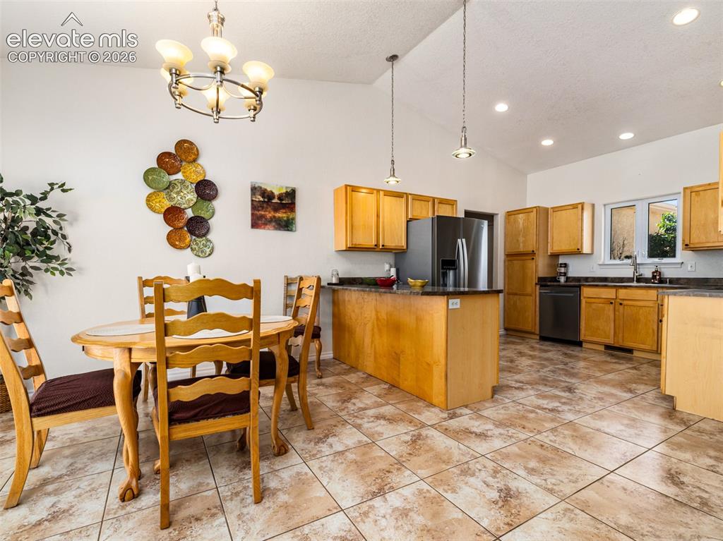 Image 43 of 49: Vaulted ceilings above a dining area with a circular chandelier