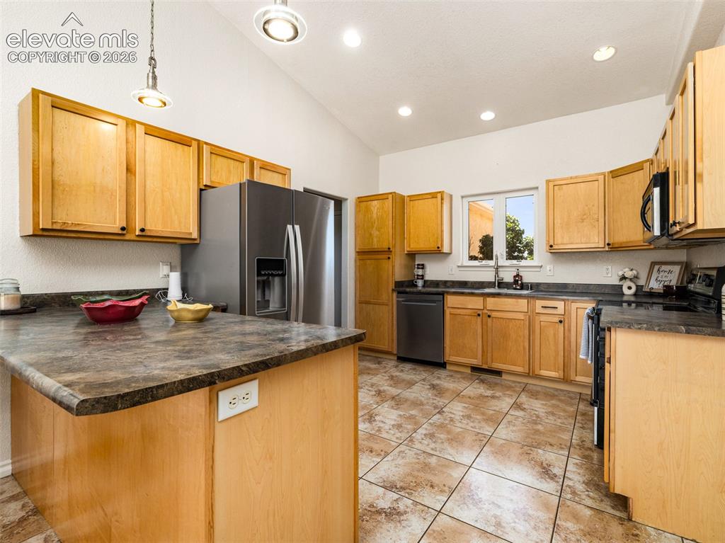 Image 44 of 49: Vaulted ceilings, recessed lighting, wood cabinetry, stainless steel applia