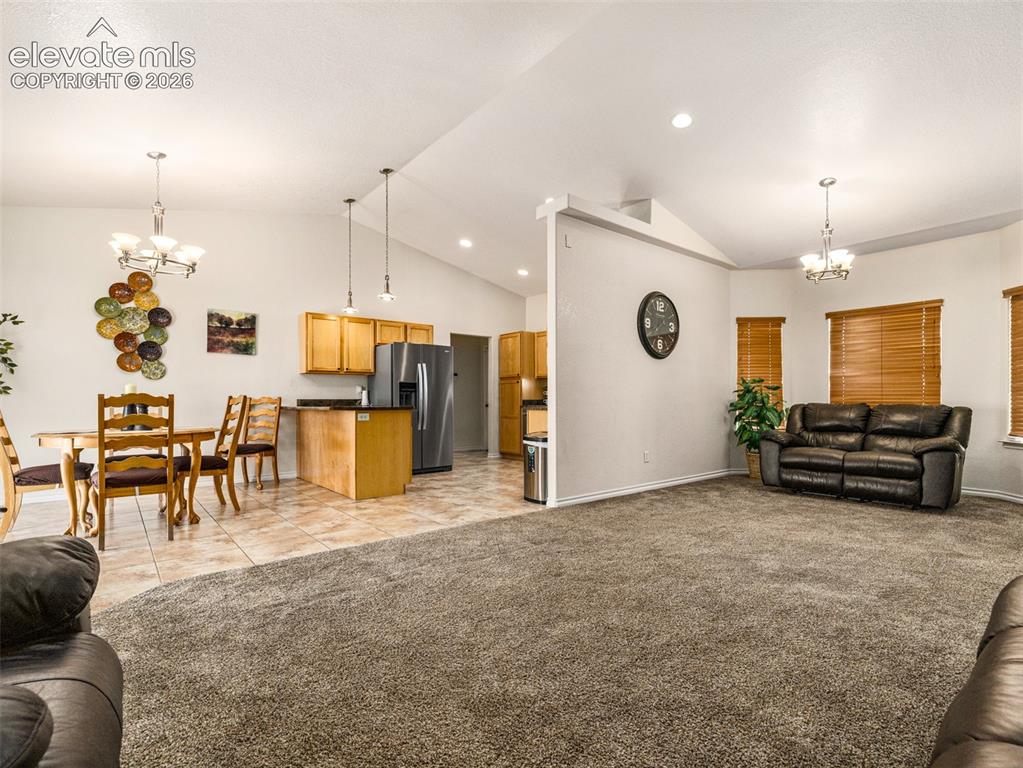 Image 6 of 49: Vaulted ceilings with recessed lighting, tile flooring, wood-finish cabinet