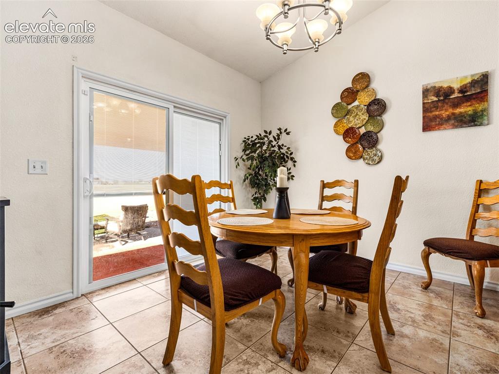 Image 7 of 49: Sliding glass door, tiled flooring, overhead light fixture, light-toned wal