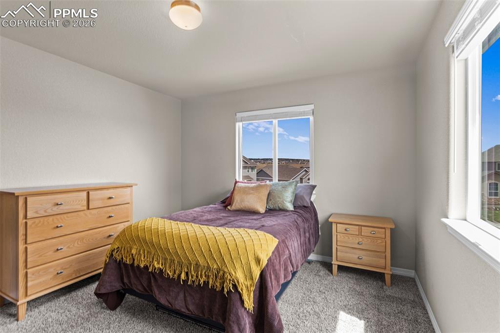Image 15 of 21: Bedroom featuring two windows, neutral-toned walls, and grey carpet floorin