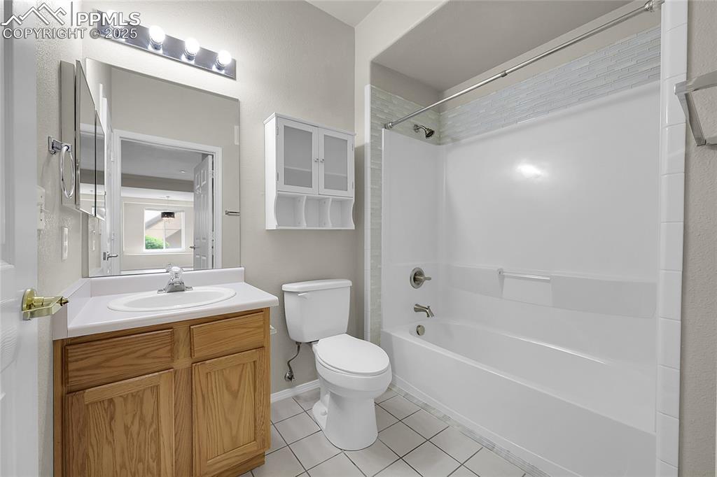 Image 10 of 18: Bathroom with tile patterned floors, vanity, and shower / washtub combinati