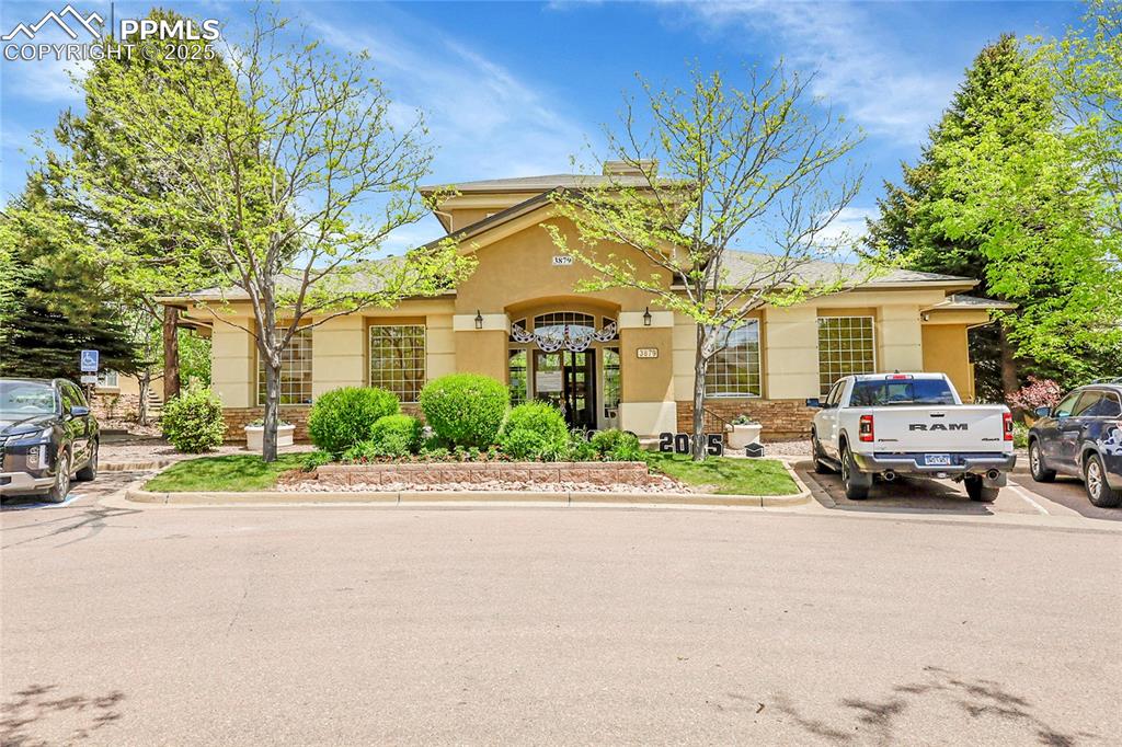 Image 14 of 18: View of front of property featuring stucco siding and brick siding