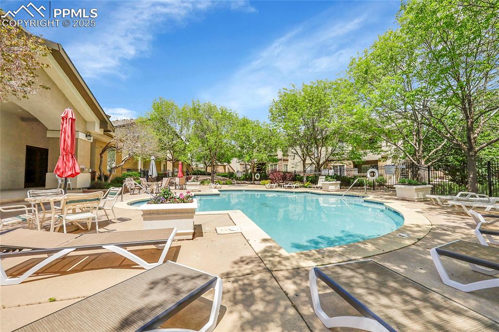 Image 18 of 18: Community pool with a patio area