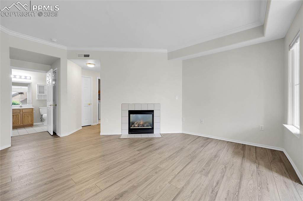 Image 4 of 18: Unfurnished living room featuring light wood finished floors, crown molding