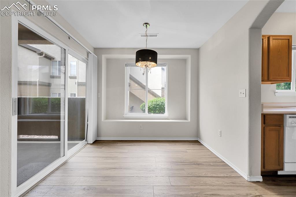 Image 5 of 18: Unfurnished dining area with light wood-type flooring and baseboards