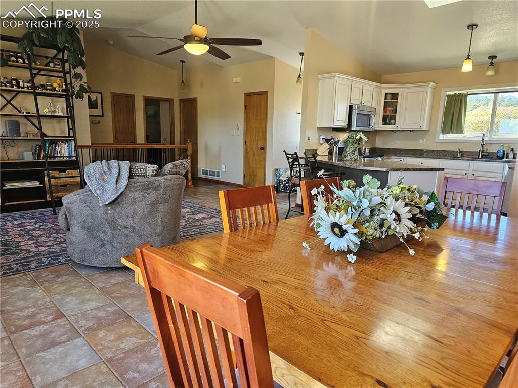 Image 10 of 44: Dining area featuring vaulted ceiling and ceiling fan
