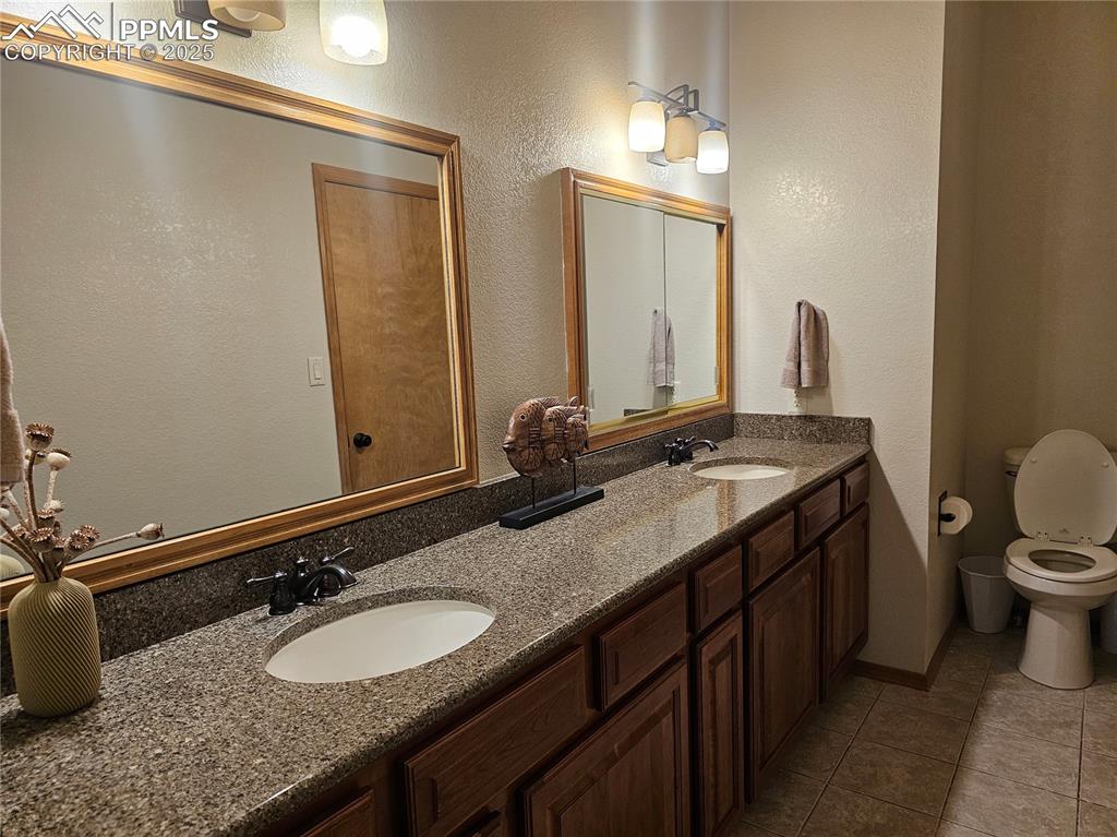 Image 14 of 44: Master Bathroom, double vanity, and dark tile patterned flooring