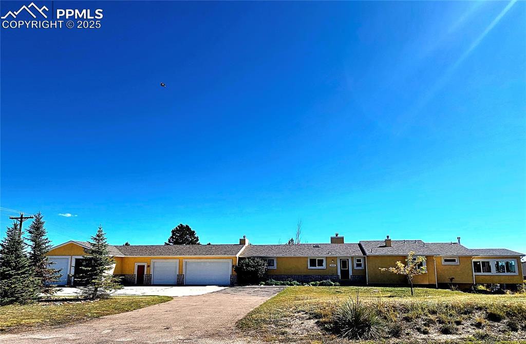Image 2 of 44: Single story home with a chimney, driveway, a front yard, a garage, and sto