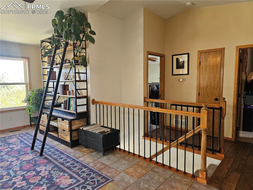Image 5 of 44: Dinning Room with Book Shelves and stairs to basement.
