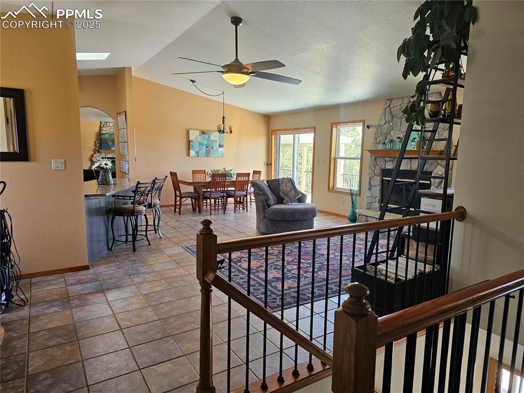 Image 6 of 44: Living area featuring lofted ceiling, ceiling fan, arched walkways, with a 