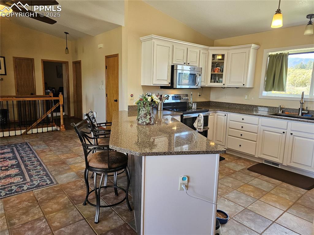Image 8 of 44: Kitchen with pendant lighting, vaulted ceiling, a kitchen breakfast bar, ap