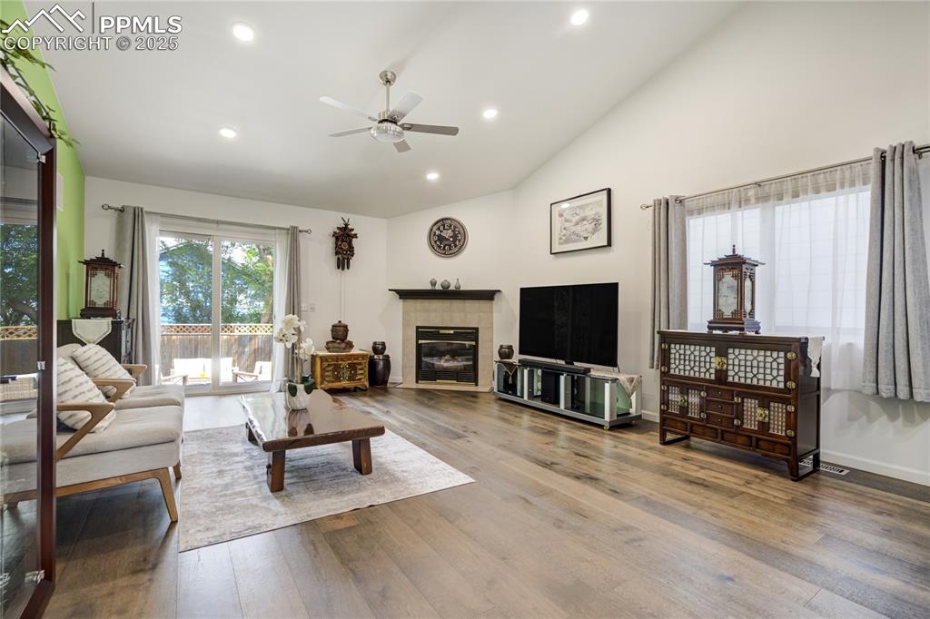 Image 2 of 43: Wood floors and gas fireplace - walkout to patio