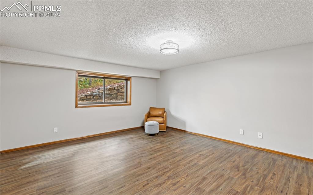 Image 19 of 21: Spare room featuring wood finished floors and a textured ceiling