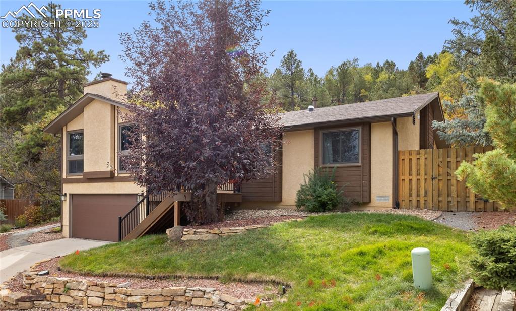 Image 3 of 21: View of front of house featuring stucco siding, stairway, a garage, a chimn