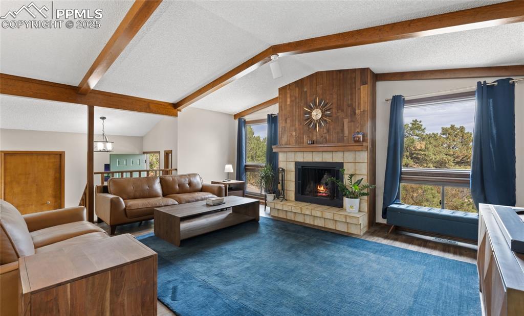 Image 6 of 21: Living room featuring a textured ceiling, wood finished floors, and a tiled