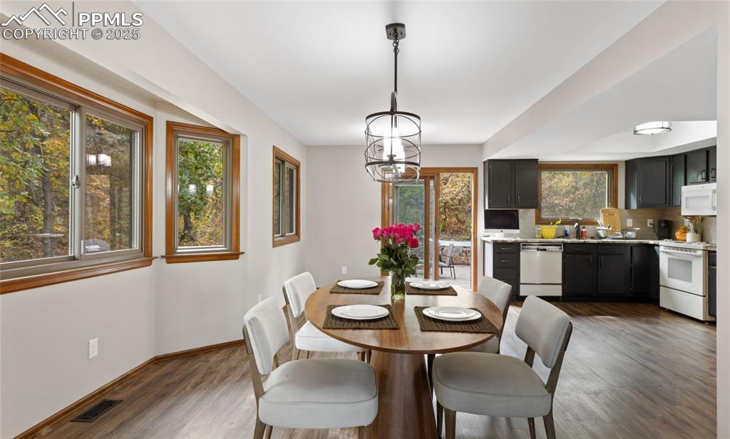 Image 7 of 21: Dining area with a chandelier and dark wood-type flooring