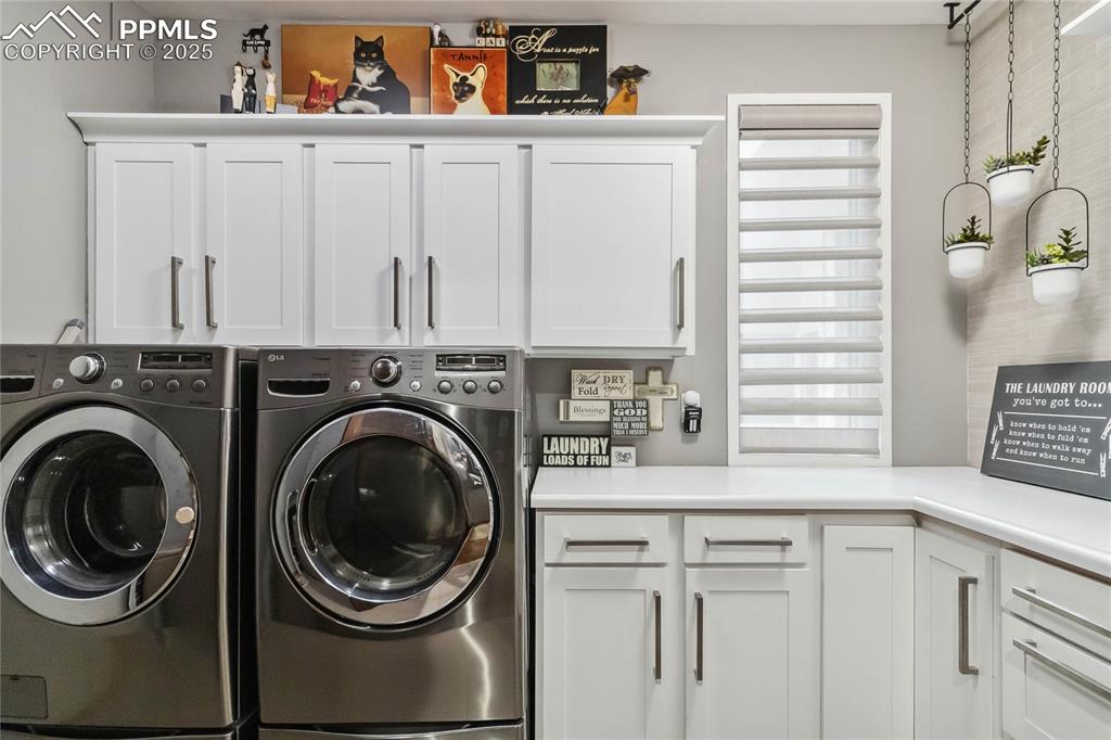 Image 32 of 48: Main Floor Laundry room with cabinets and utility sink.