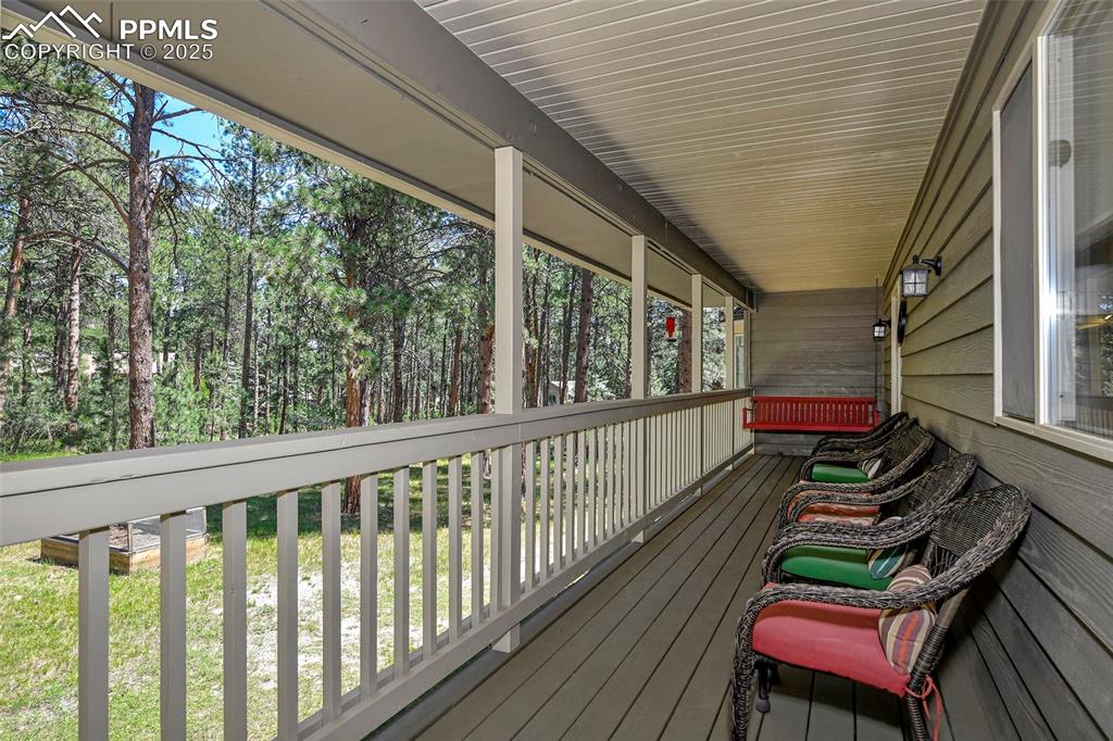 Image 3 of 50: Long covered front porch with porch swing