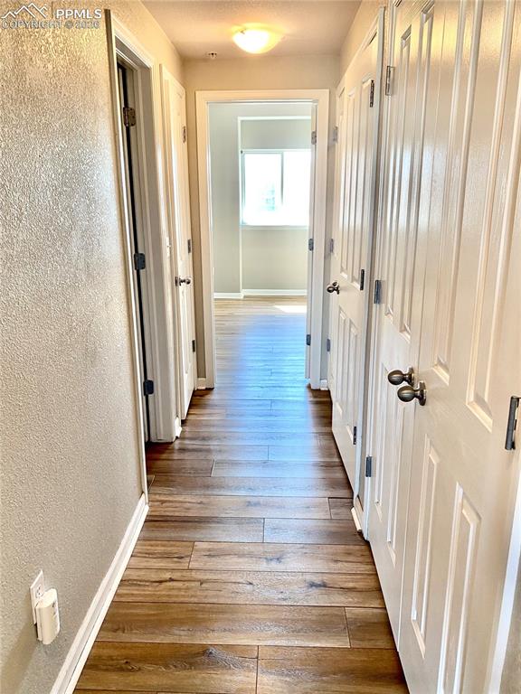 Image 12 of 21: Hallway between the two bedrooms, one full bathroom in the hallway, laundry