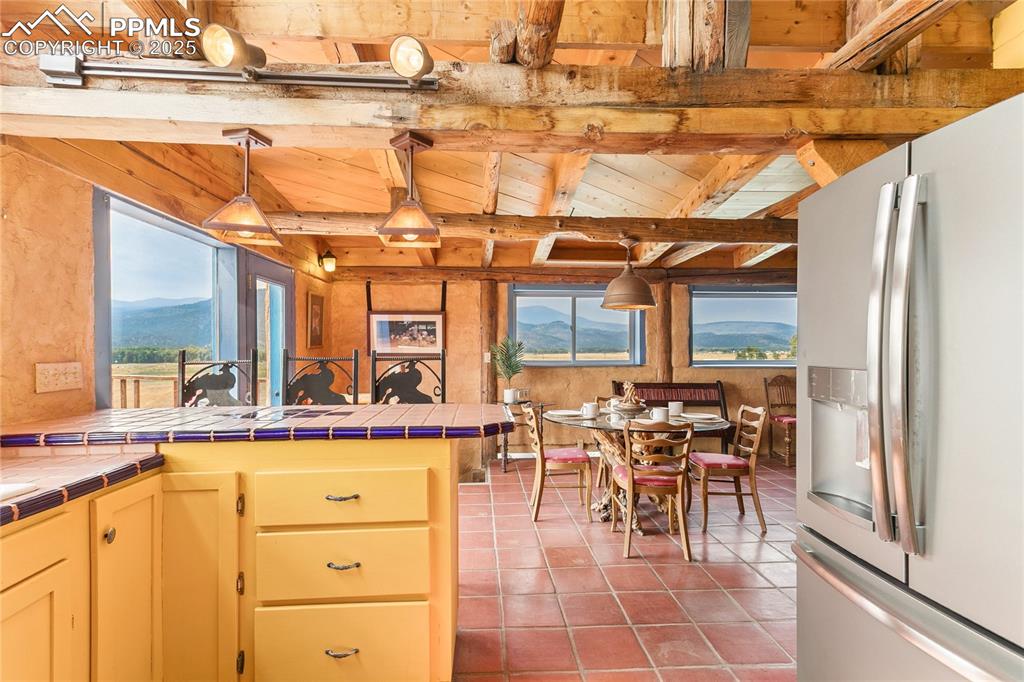 Image 15 of 50: Kitchen featuring stainless steel fridge with ice dispenser, pendant lighti