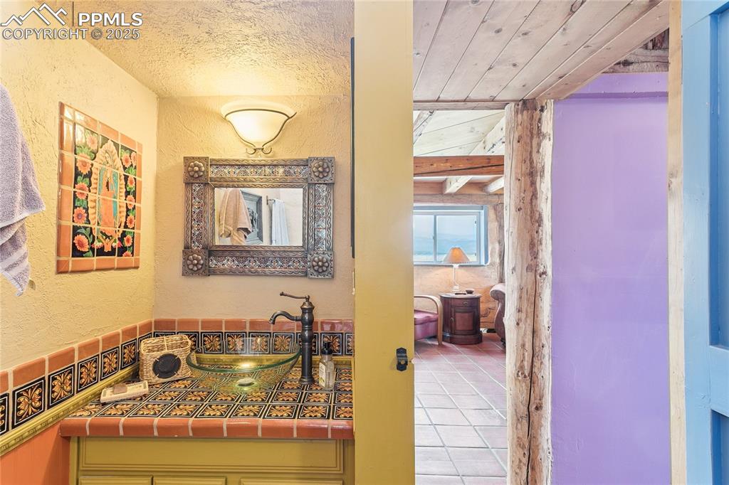 Image 19 of 50: 3/4 Bathroom featuring a textured wall, vanity, and tile patterned floors